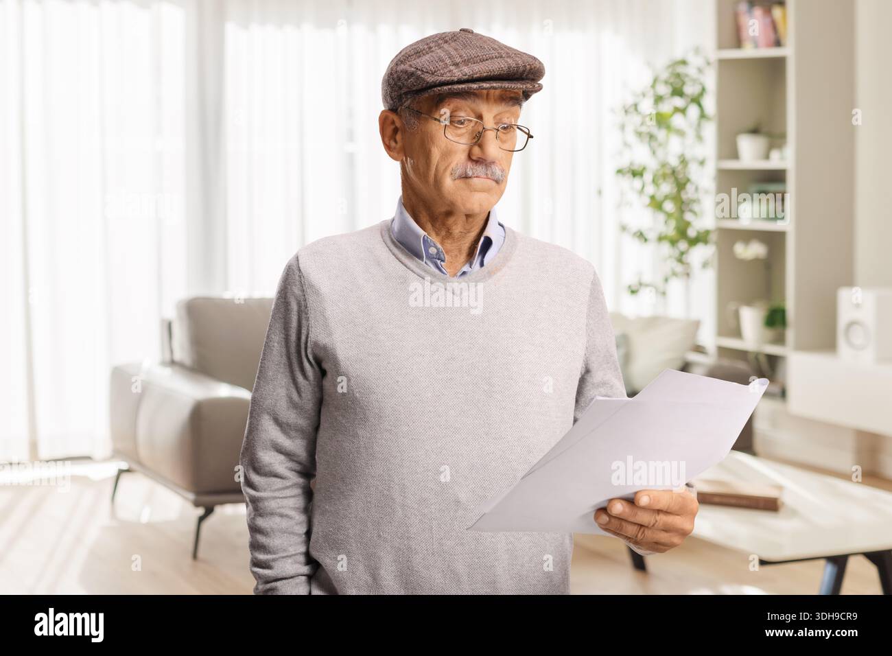 Confused senior man reading a document at home Stock Photo