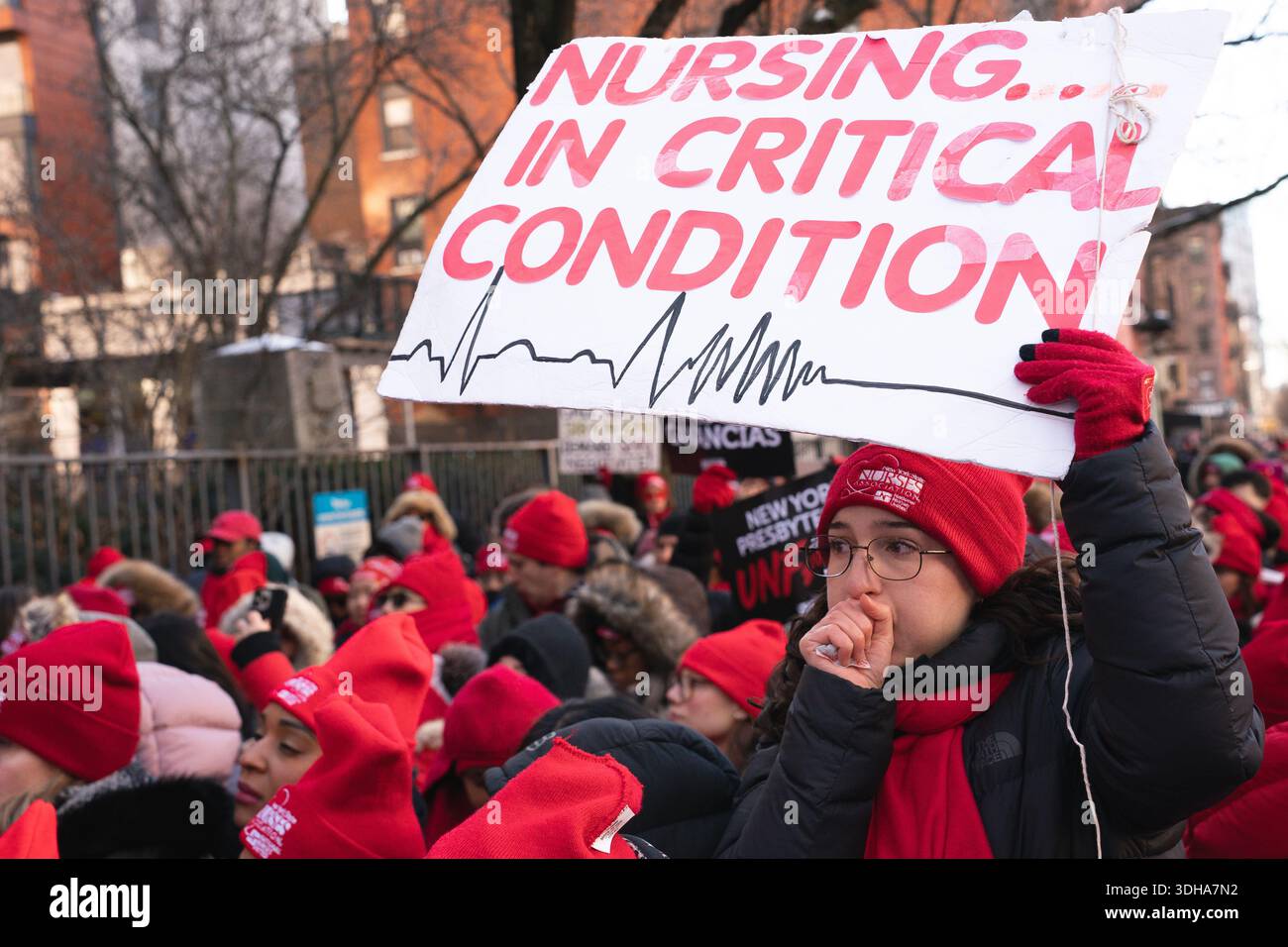 A nurse of the New York State Nurses Association warms her hand during ...
