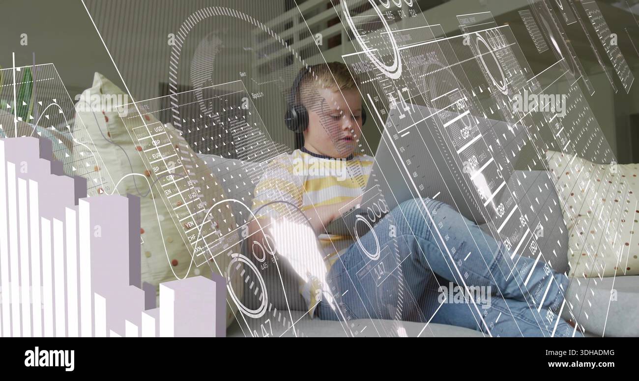 Sitting boy wearing yellow long-sleeve shirt, using tablet at home on sofa with headset, AR overlay Stock Photo