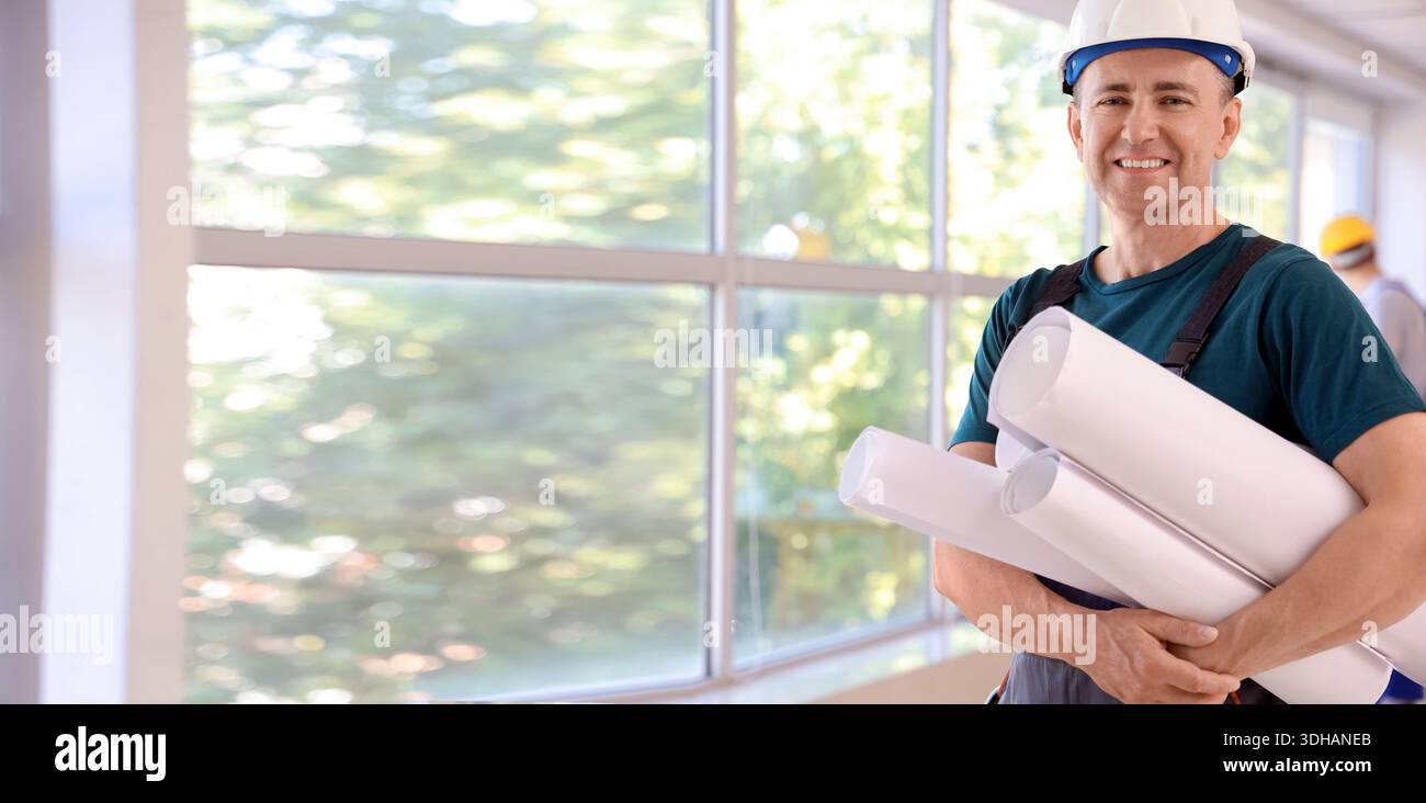 Mature engineer with drawings in room Stock Photo