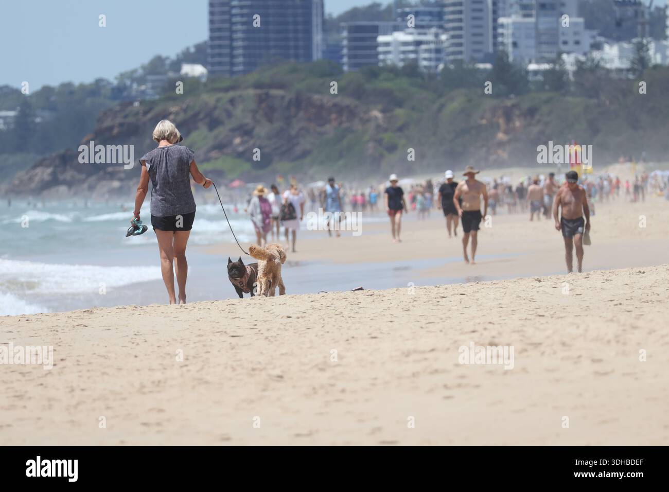 People enjoying a sunny day at the beach on the Gold Coast, relaxing on ...