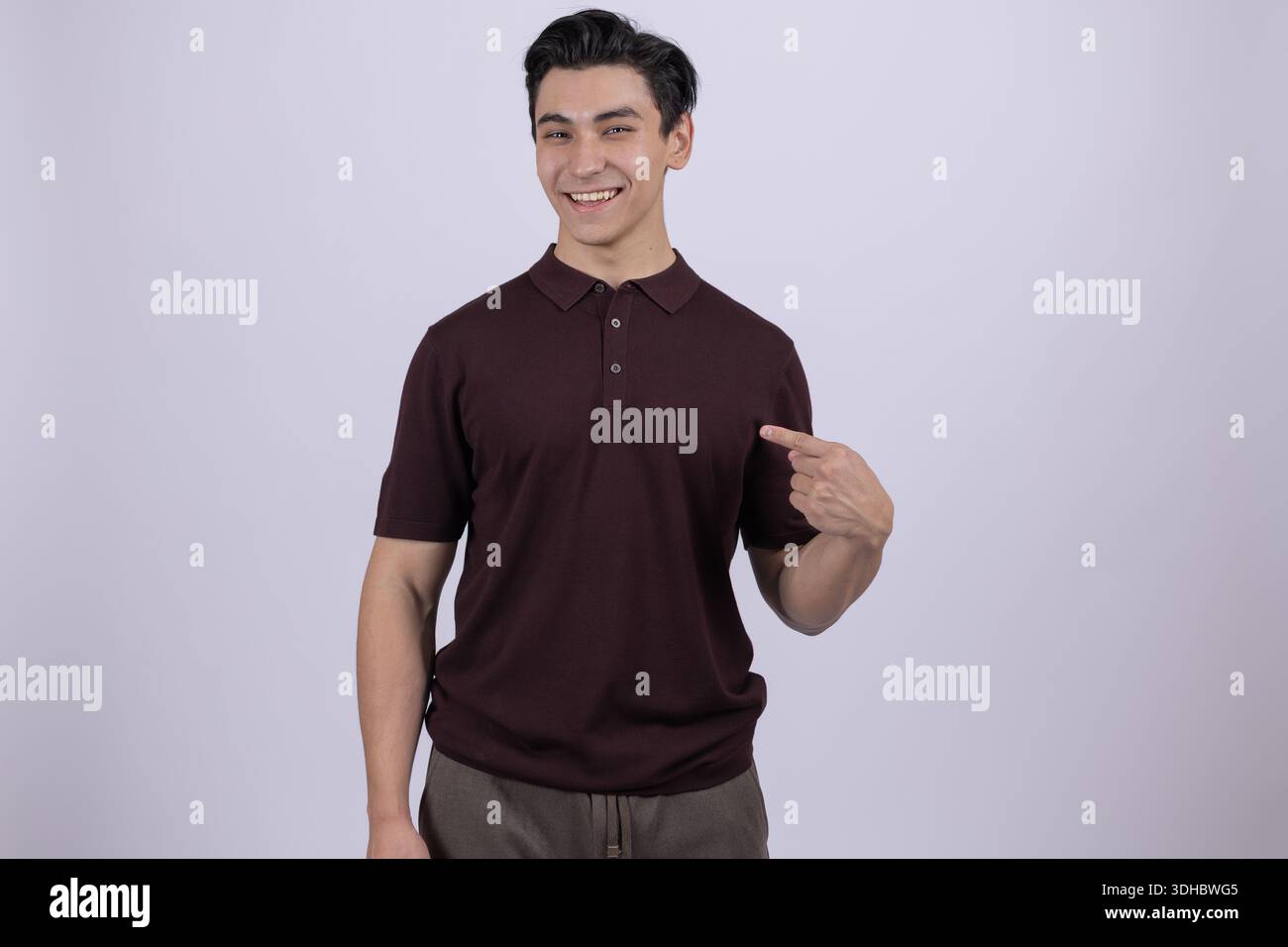 Man in brown shirt pointing himself and looking at camera Stock Photo