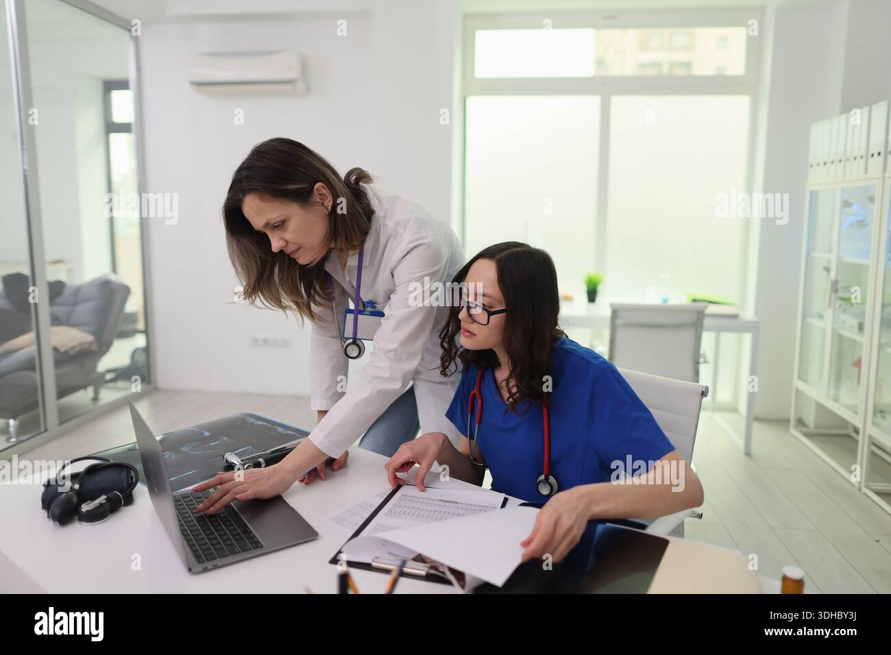 Medical professionals collaborating in a modern clinic during a busy workday Stock Photo