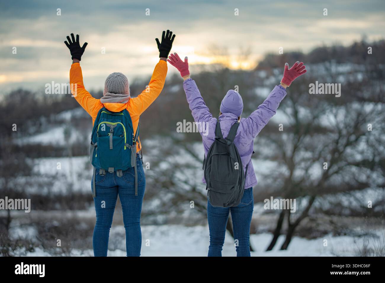 Two people celebrating winter hiking success outdoors Stock Photo