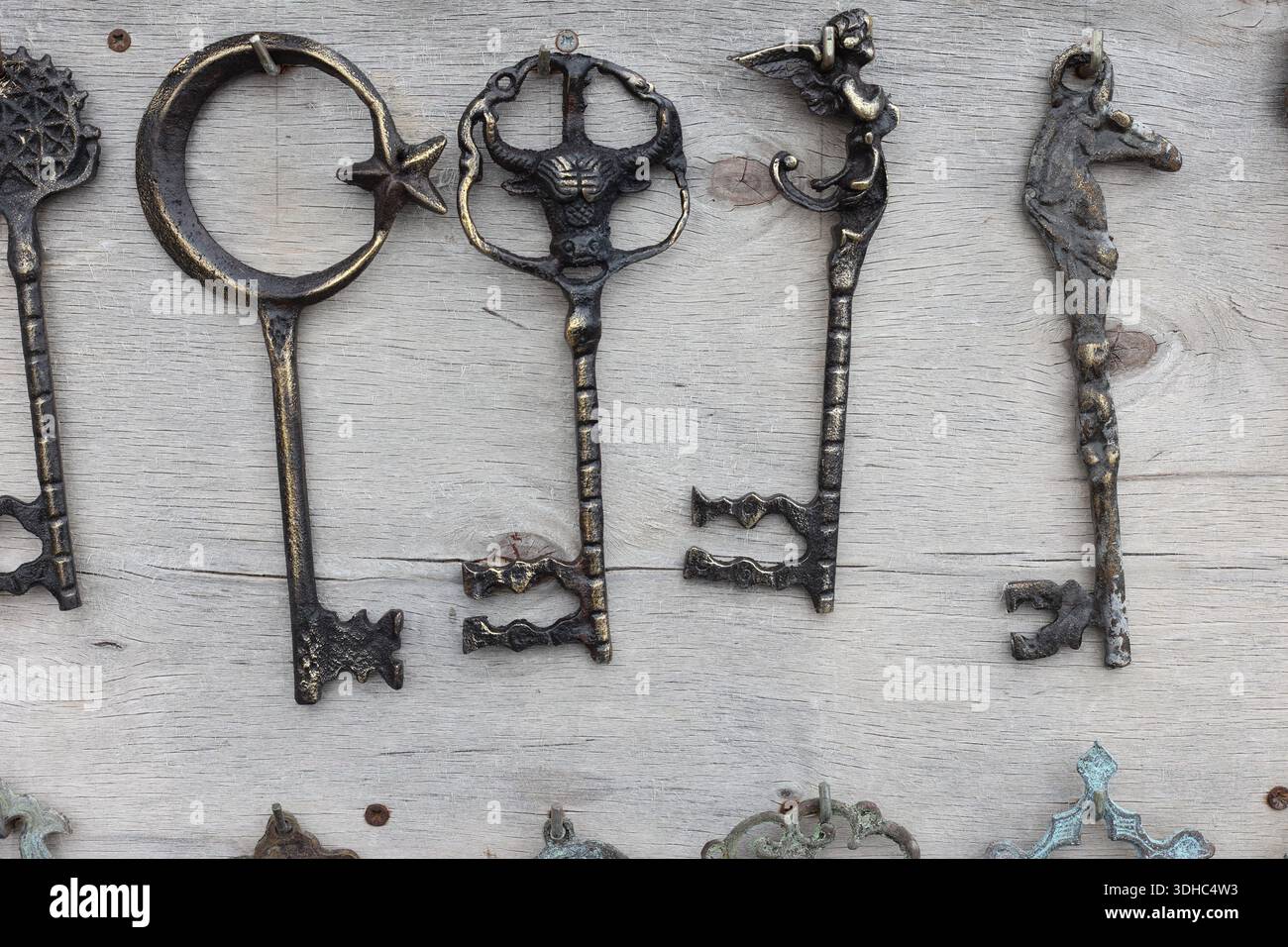 a collection of antique keys hanging on the wall Stock Photo