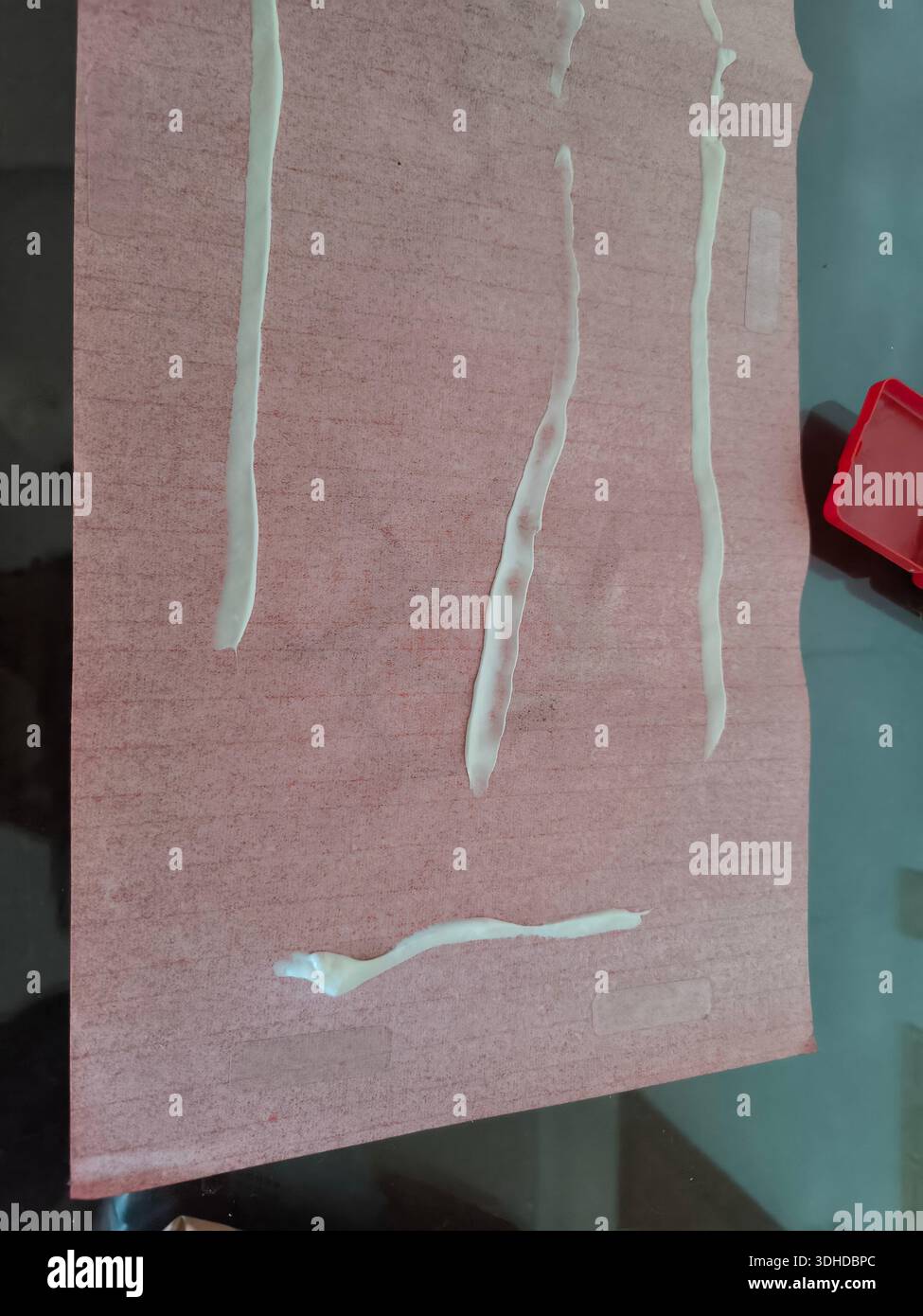 White adhesive lines on pink textured paper surface Stock Photo