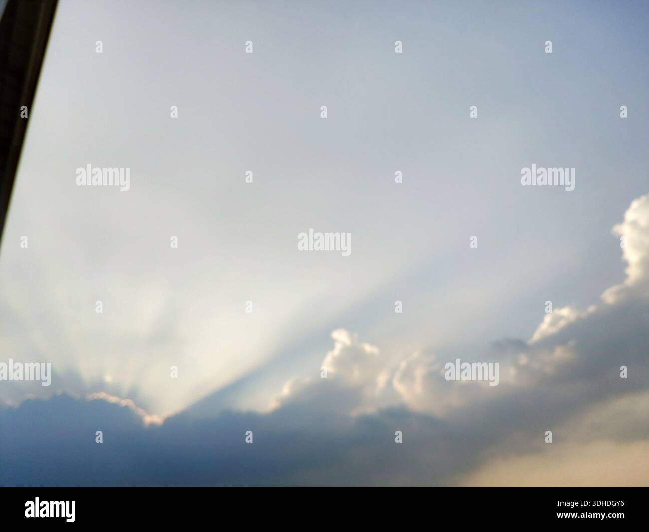 Sunlight Breaking Through Clouds at Sunset Stock Photo