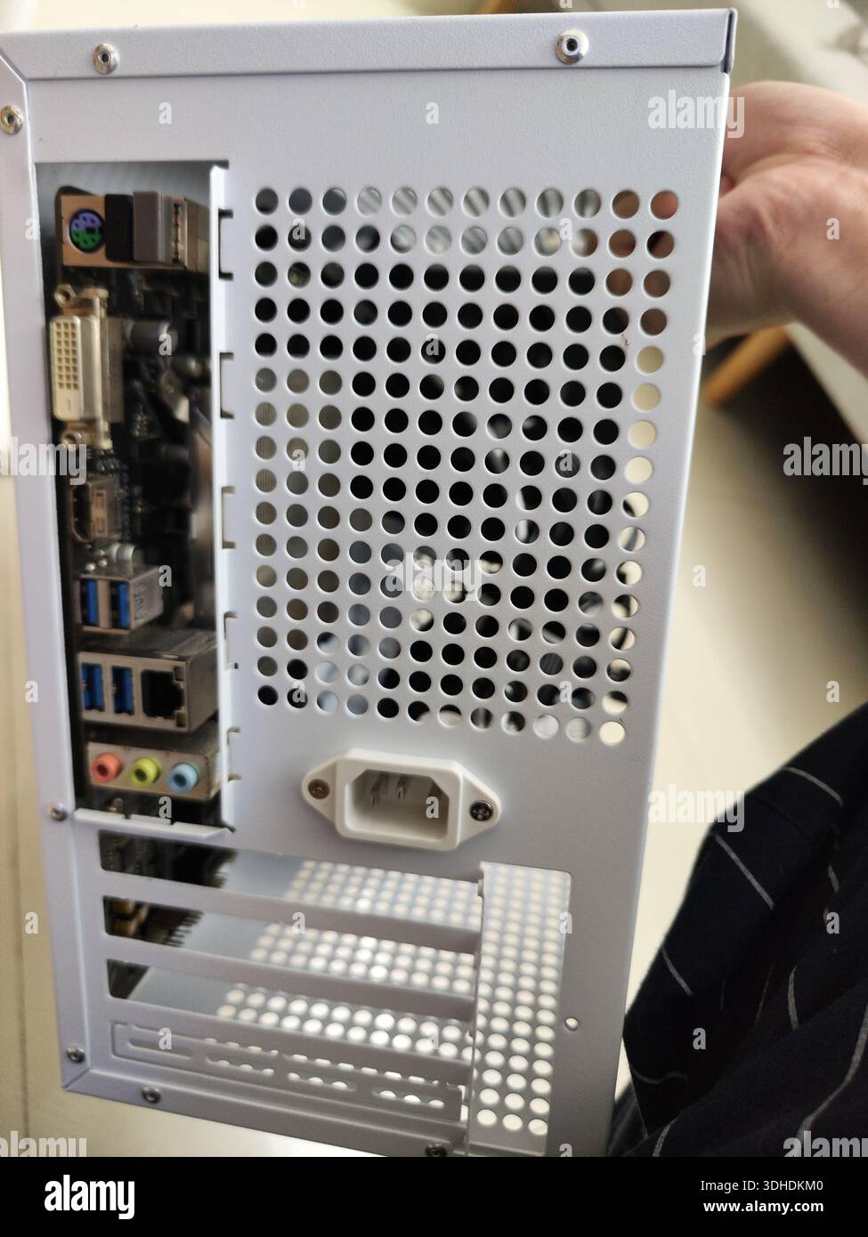 Close-up of a computer case rear panel with ports and ventilation holes Stock Photo