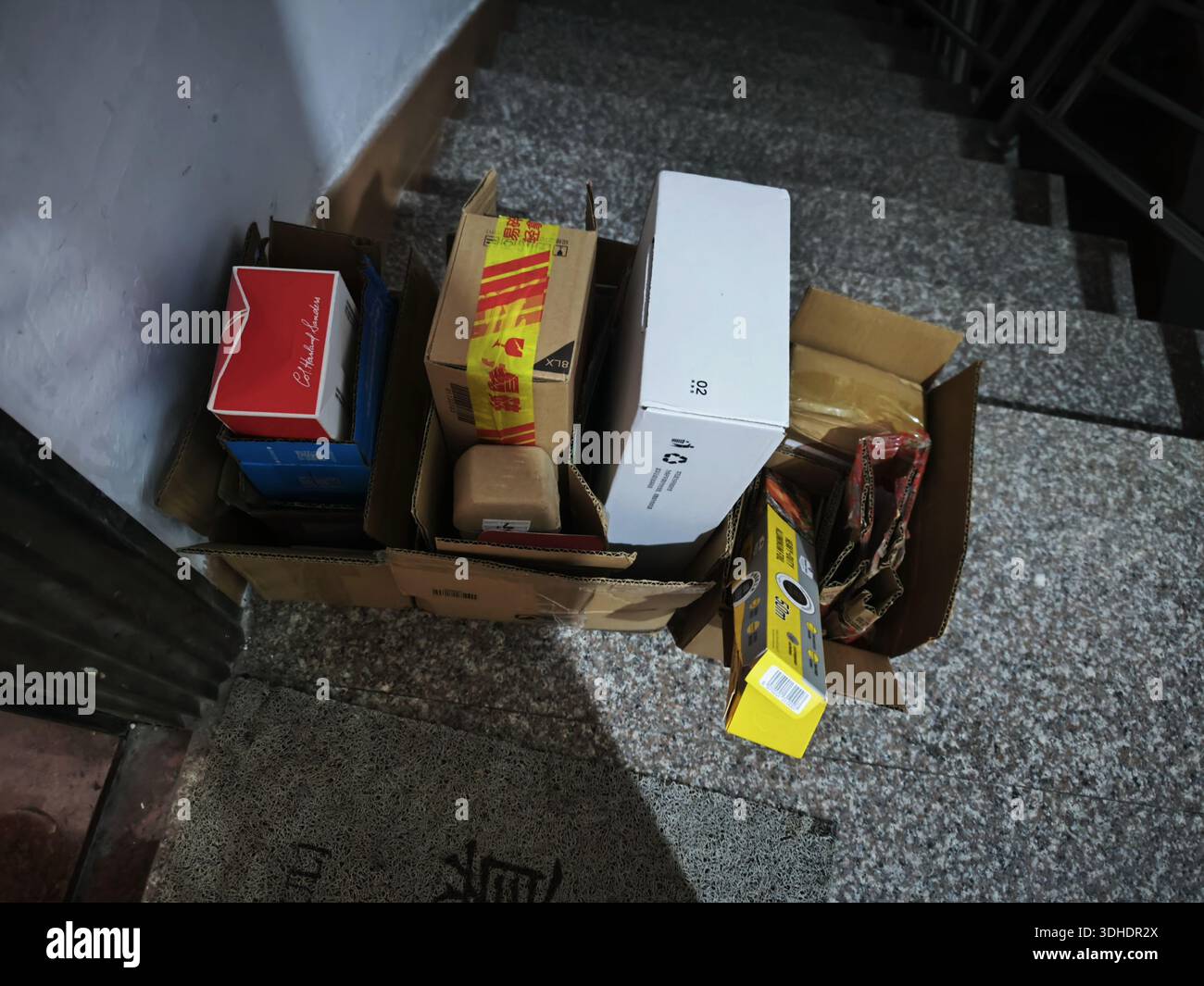 Piled cardboard boxes and packaging materials on staircase landing Stock Photo