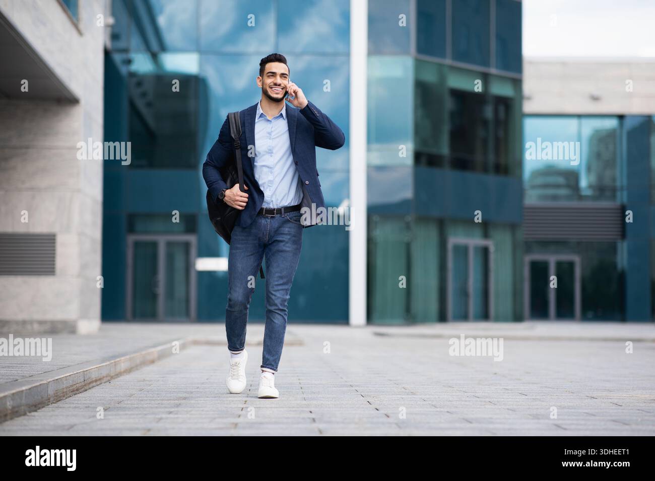 Young middle-eastern entrepreneur going home, talking on phone Stock Photo