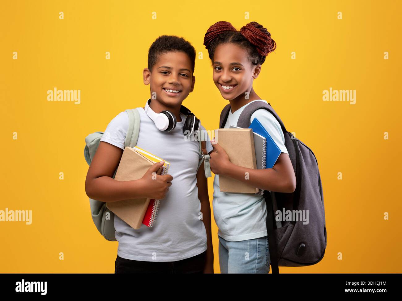 Positive black boy and girl schoolers holding books Stock Photo - Alamy