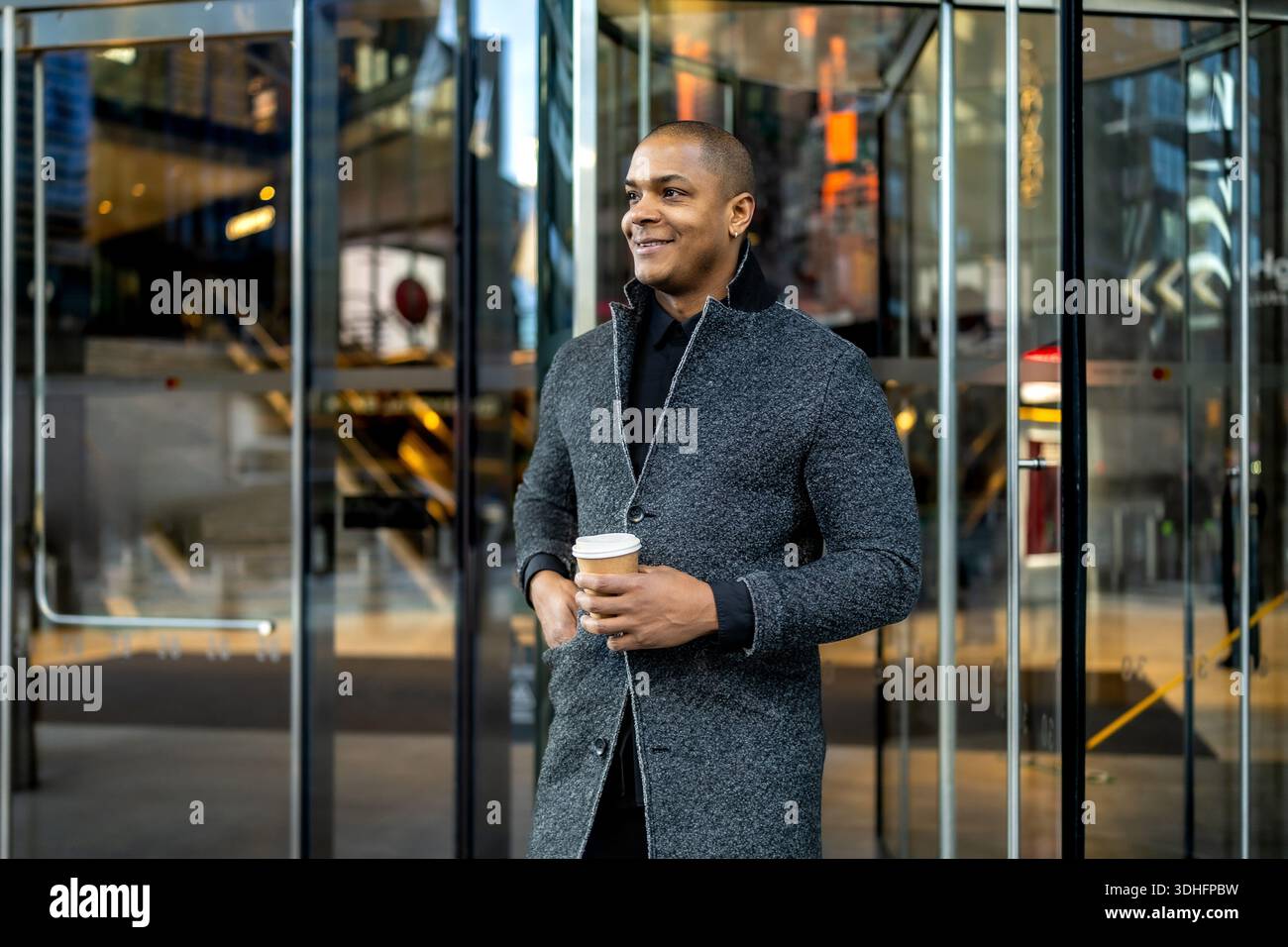 Confident businessman commuting holding coffee in city Stock Photo
