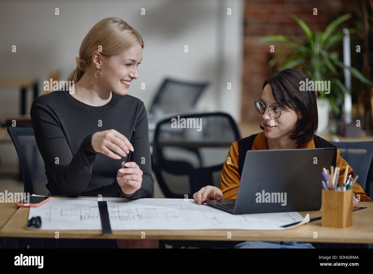 Young Woman with Disability Working with Colleague on Architectural Project Stock Photo