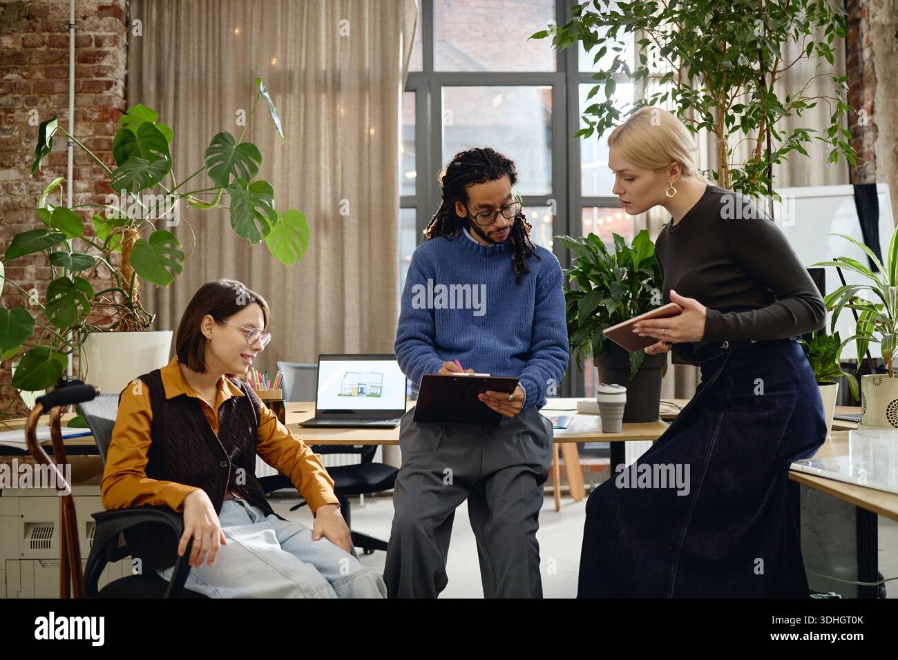 Multiethnic Young Adults Collaborating on Project in Modern Office Setting Stock Photo
