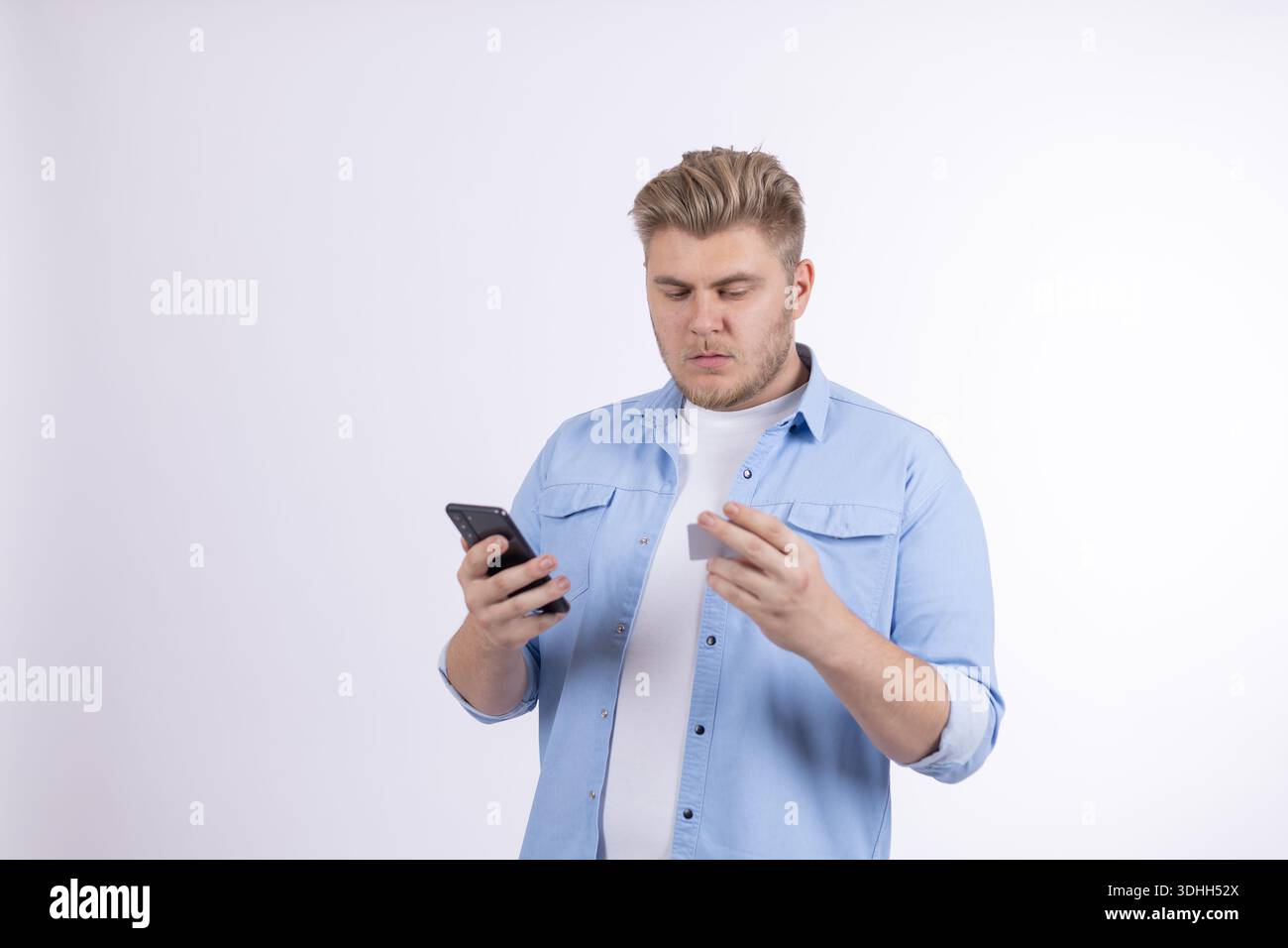 Man using smartphone and smiling in a studio Stock Photo
