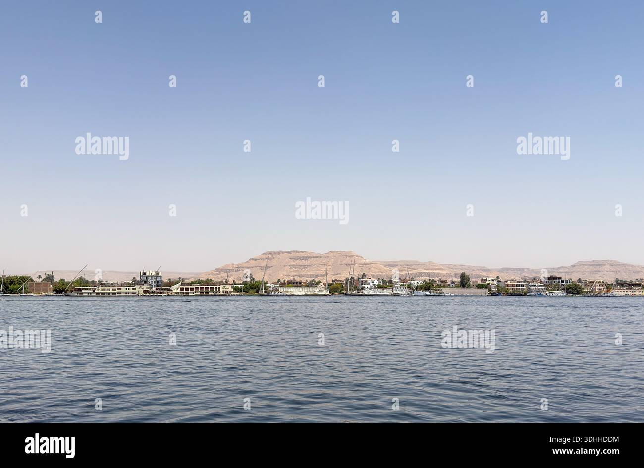Ägypten Nil: Dorf mit Turm, Palmen und blauem Boot am Ufer - Smartphone Captured Stock Image