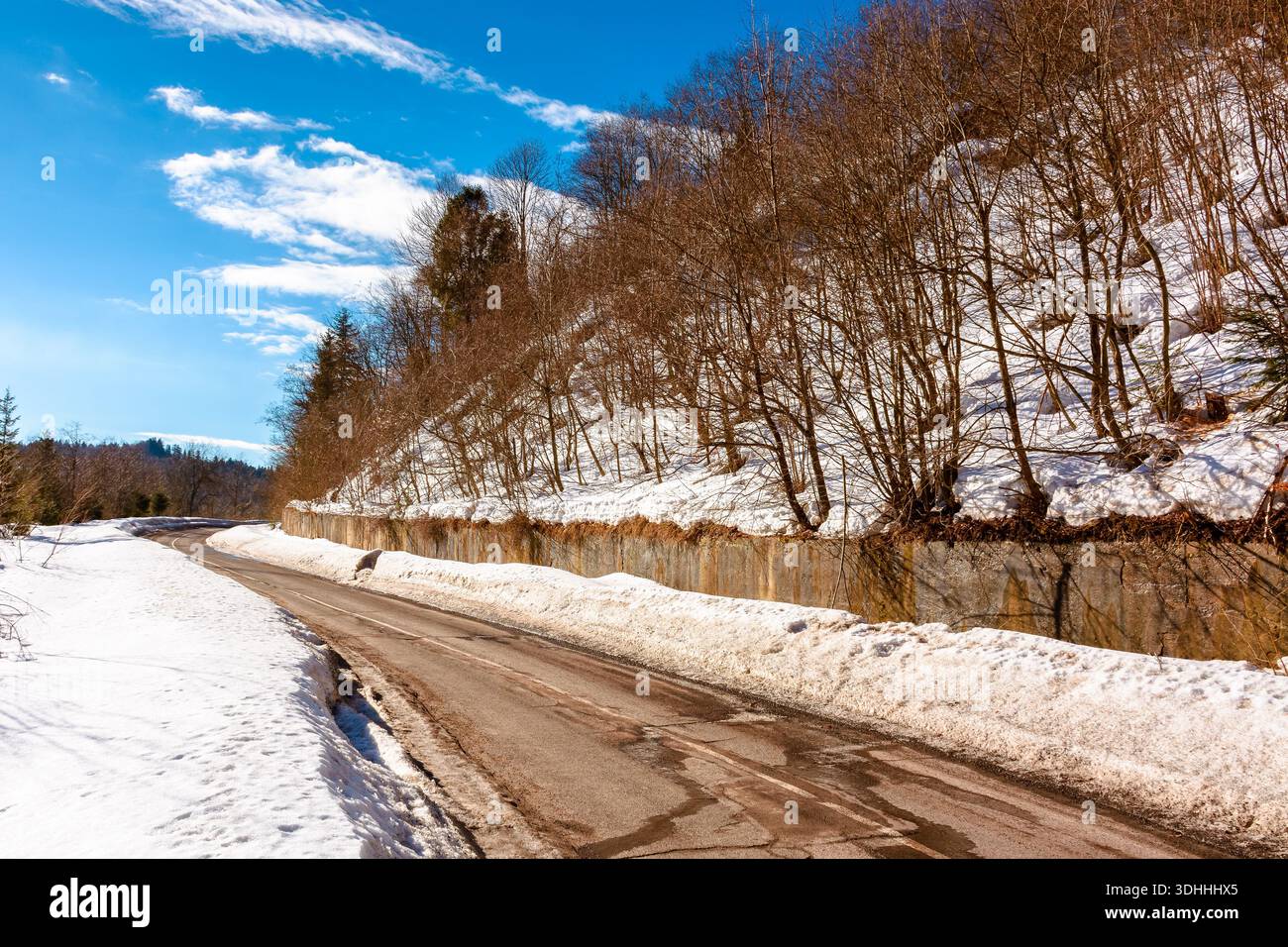 country road winding through winter landscape under blue sky. great bereznyi district of carpathian mountains on a sunny day. scenic view of uzhanian Stock Photo