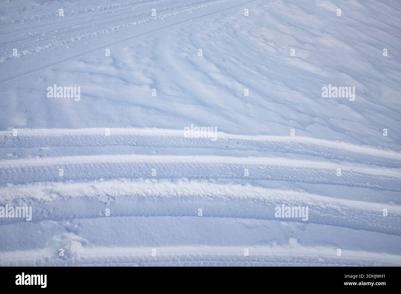 Snow surface texture with intersecting tire tracks and soft winter relief Stock Photo