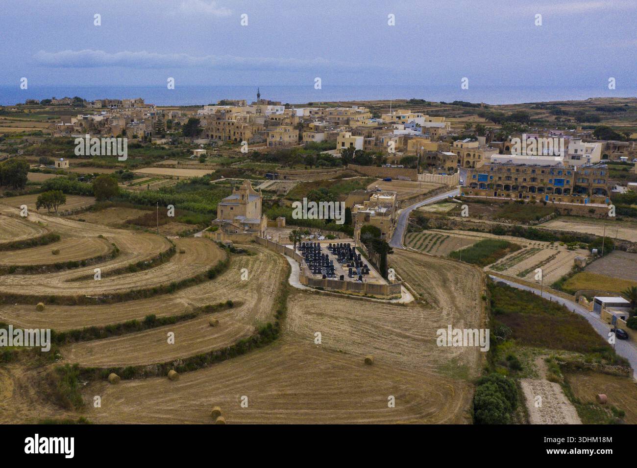Aerial view of Gozo's landscape where golden fields meet the ancient ...