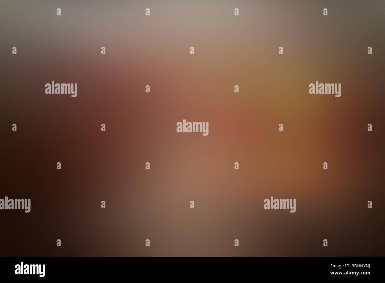A smooth, out-of-focus abstract background featuring a warm gradient of brown, tan, and dark red tones, creating a soft bokeh effect. Stock Photo