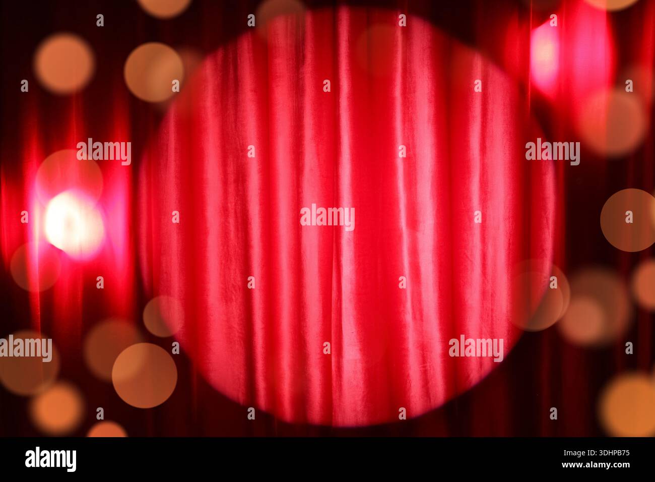 Shining spotlight on red curtain Stock Photo