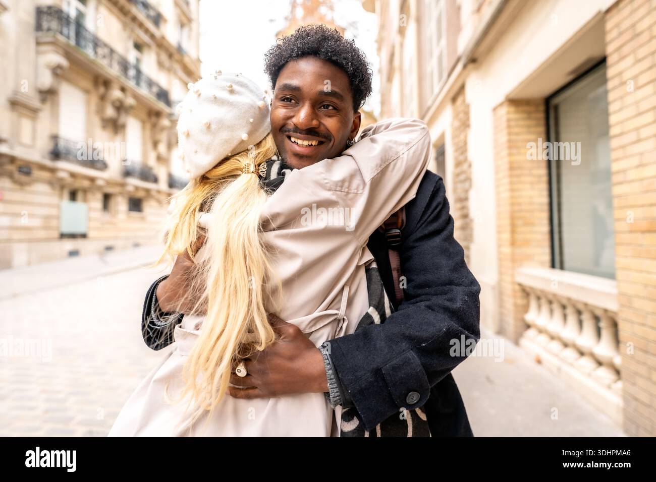 Happy diverse couple hugging on paris street Stock Photo