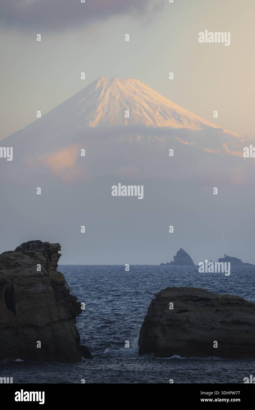 Mount Fuji Rocks View of majestic Mount Fuji rises above the sea, its snow-capped peak ...