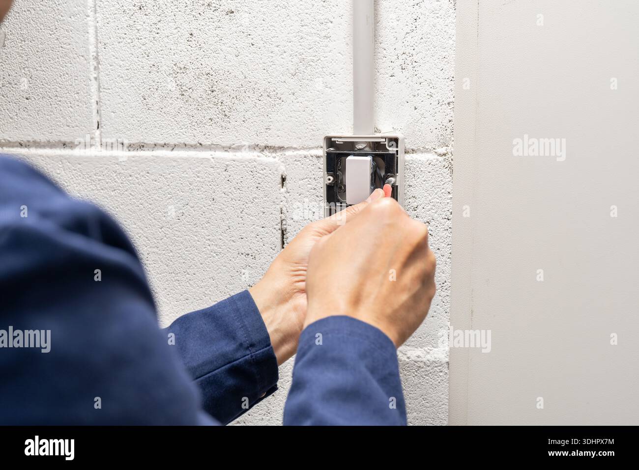 Electrician mounting electric sockets on the white wall. Electrician ...