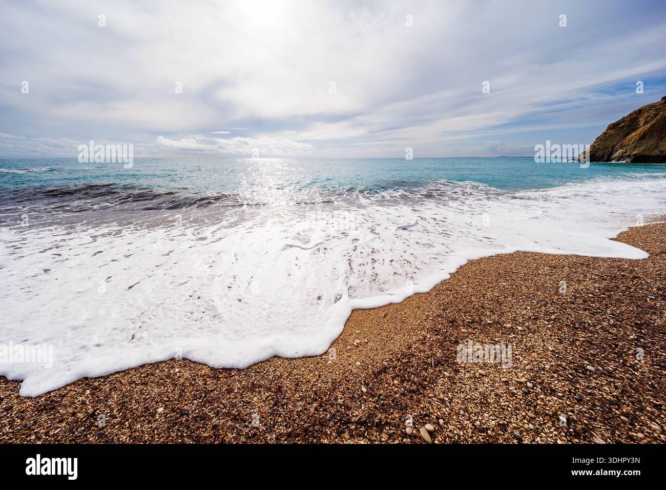 Soft Foam Edge on Pebble Shore Stock Photo