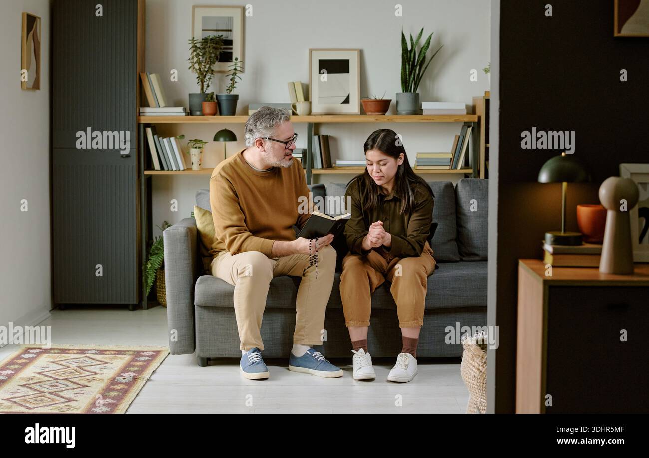 Middle Aged Man Comforting Young Adult Woman on Sofa Stock Photo - Alamy