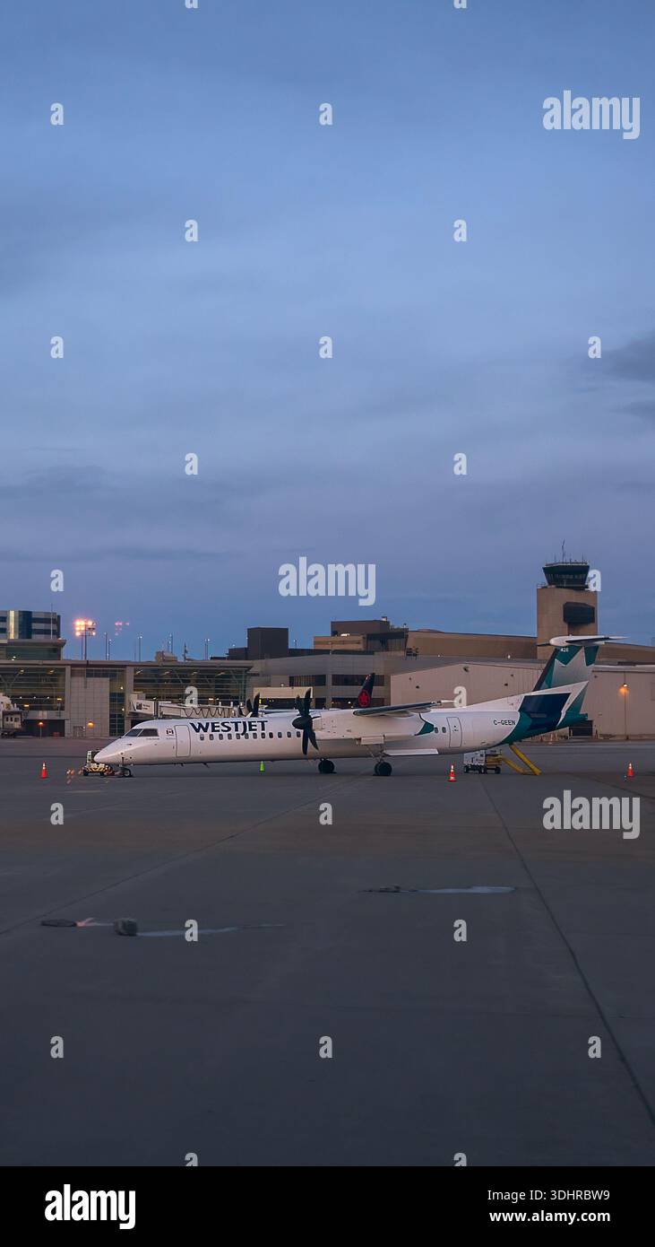 A 9:16 Portrait image of a Westjet De Havilland Dash 8-400 at Calgary Airport in Alberta, Canada - Stock Image