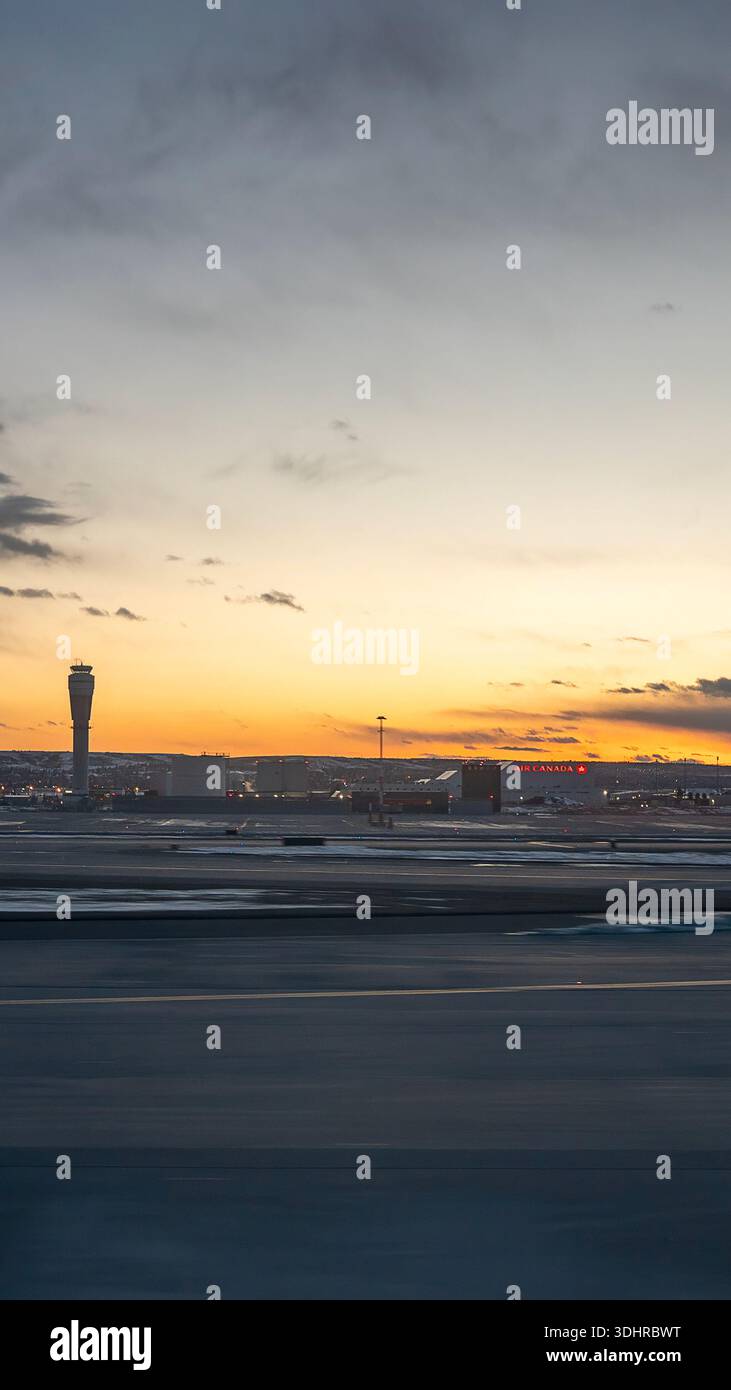 A 9:16 Portrait image of a sunset over Calgary Airport in Alberta, Canada - Stock Image