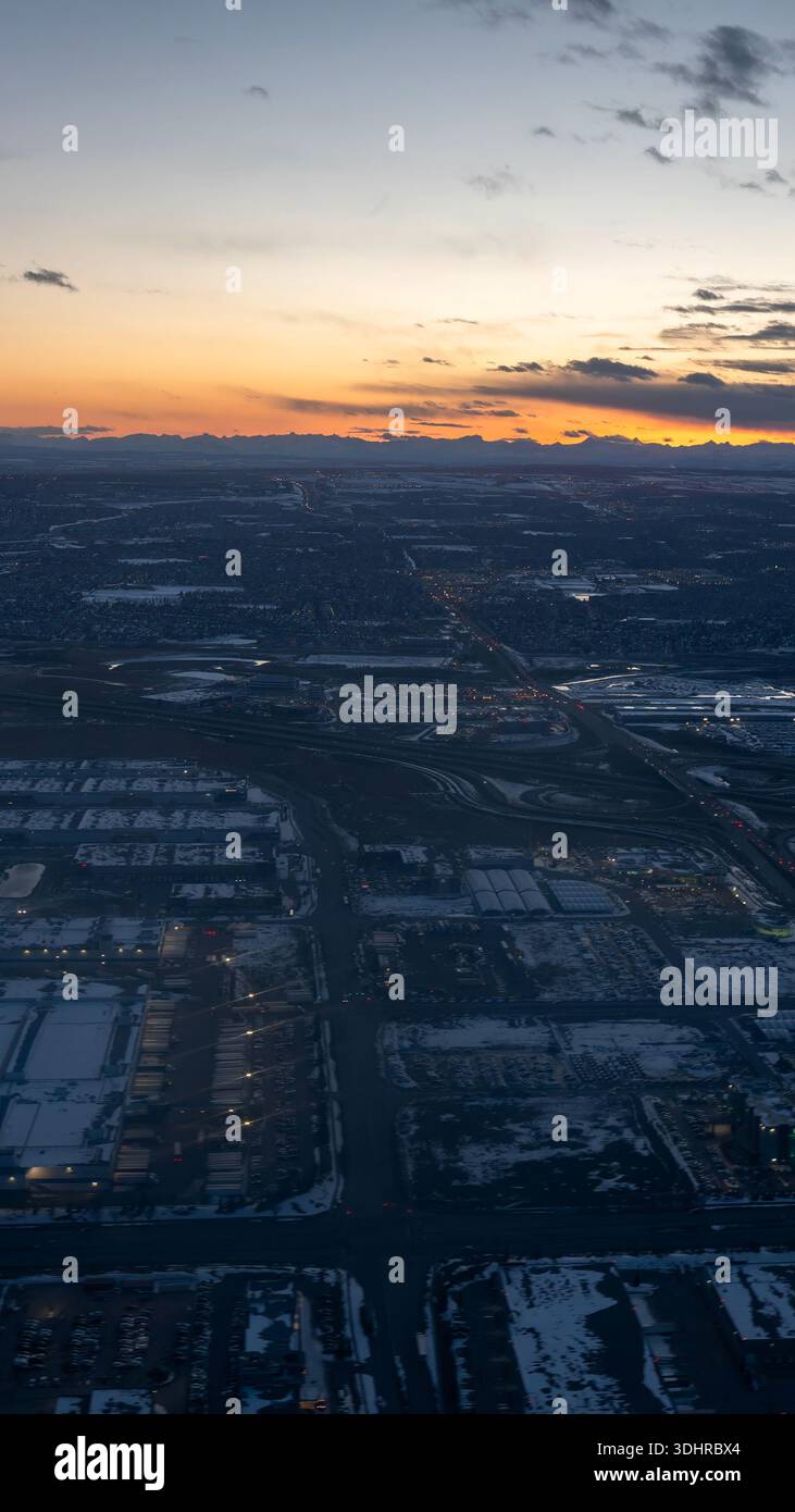 A 9:16 Portrait image of an aerial view at dusk over a snow covered city of Calgary in Alberta, Canada - Stock Image