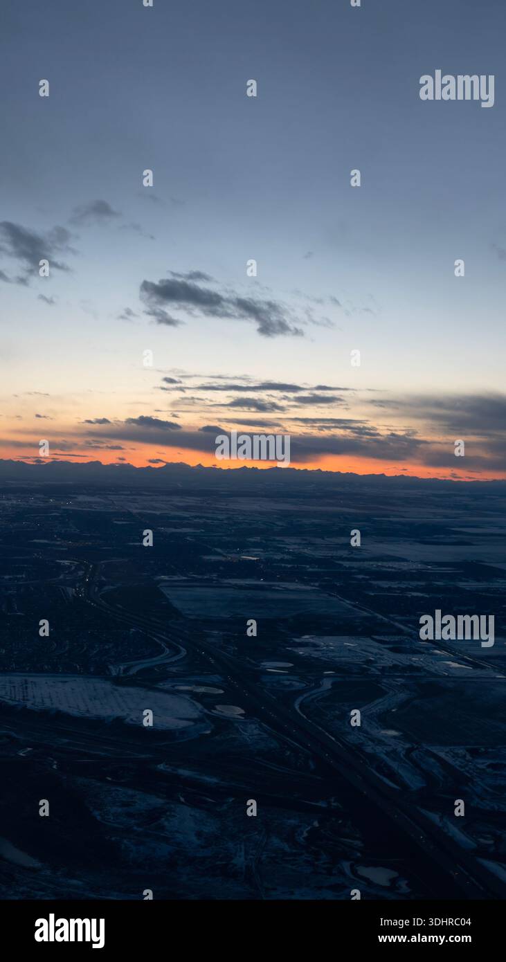 A 9:16 Portrait image of an aerial view at dusk over a snow covered city of Calgary in Alberta, Canada - Stock Image