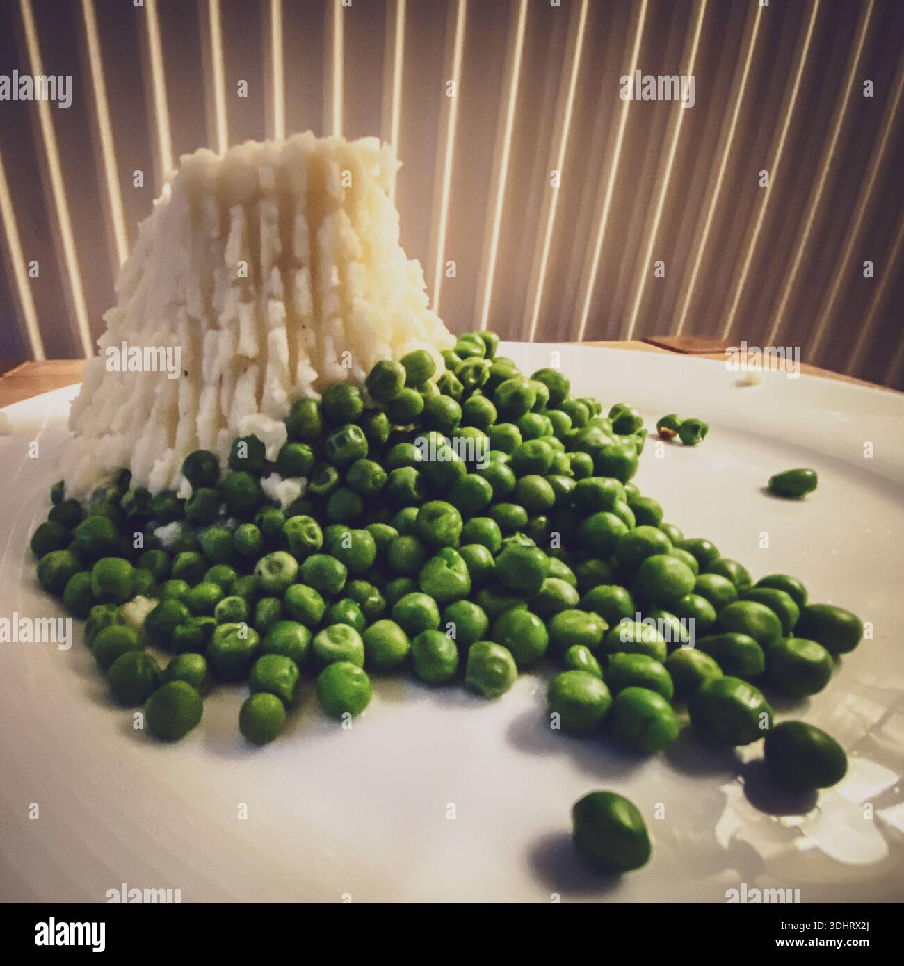 Mash potatoes and peas where the Mash potatoes are shaped to match the Devils Tower as in Close Encounters of the Third Kind - Smartphone Captured Stock Image