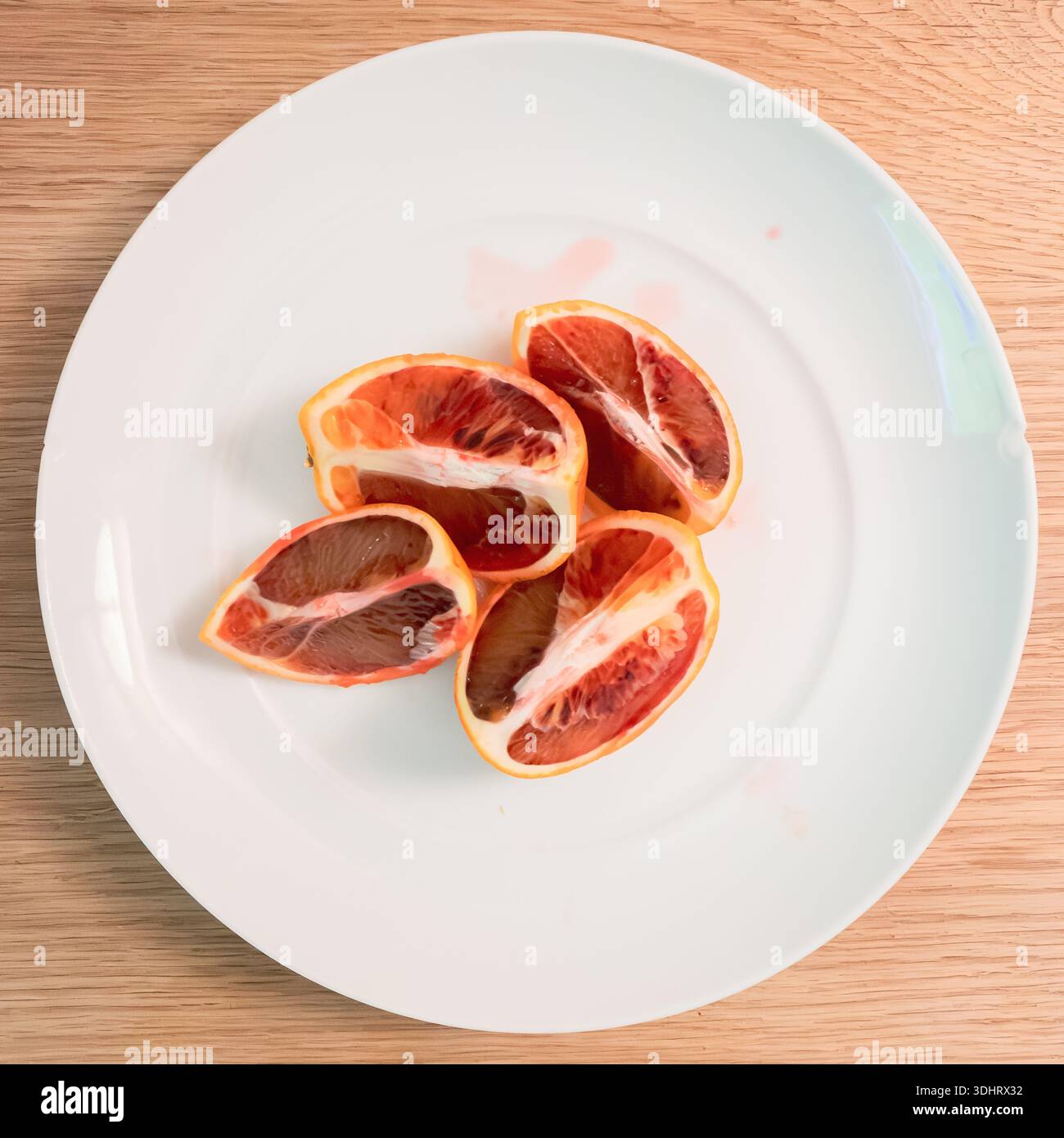 A pink grapfruit, quartered on a white plate - Smartphone Captured Stock Image