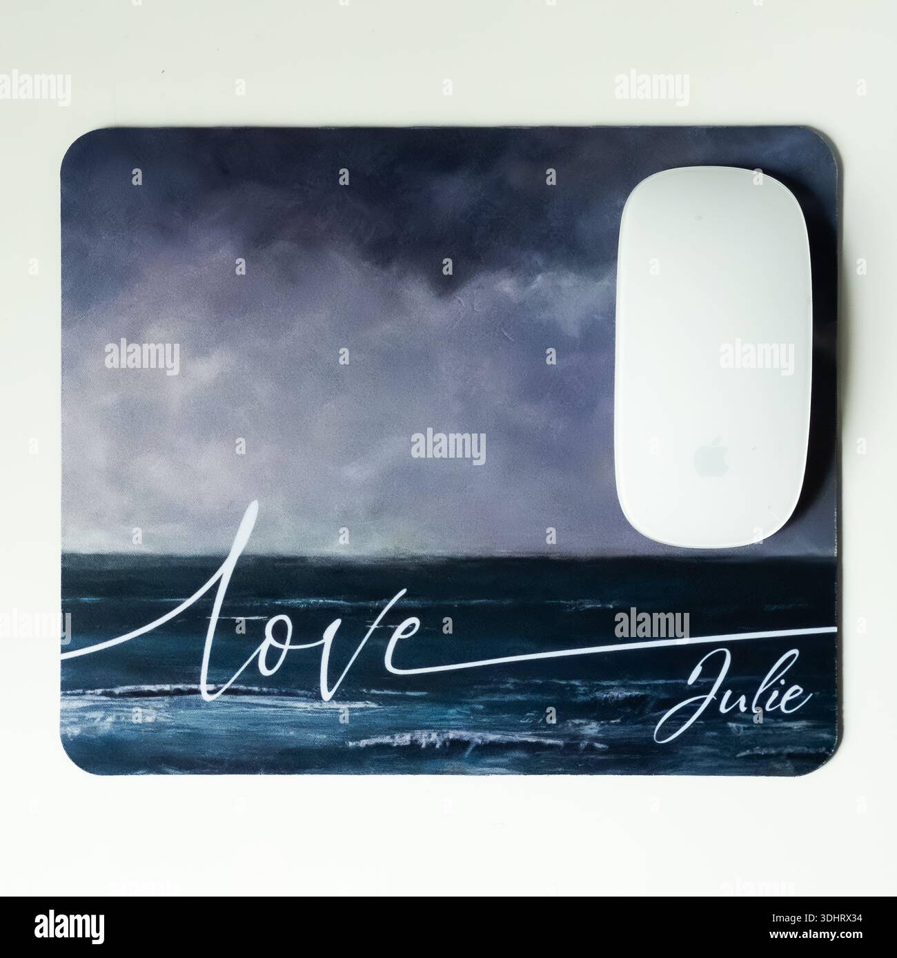 A white apple mouse on a custom art "Love" mouse mat - Smartphone Captured Stock Image