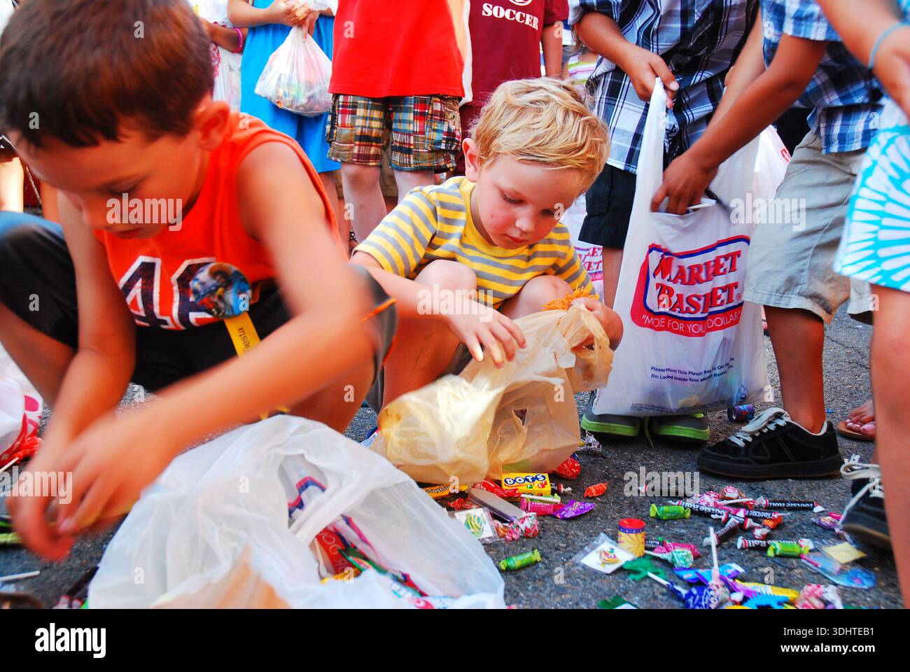 Children scurry to collect the candy after breaking a pinata at a block ...