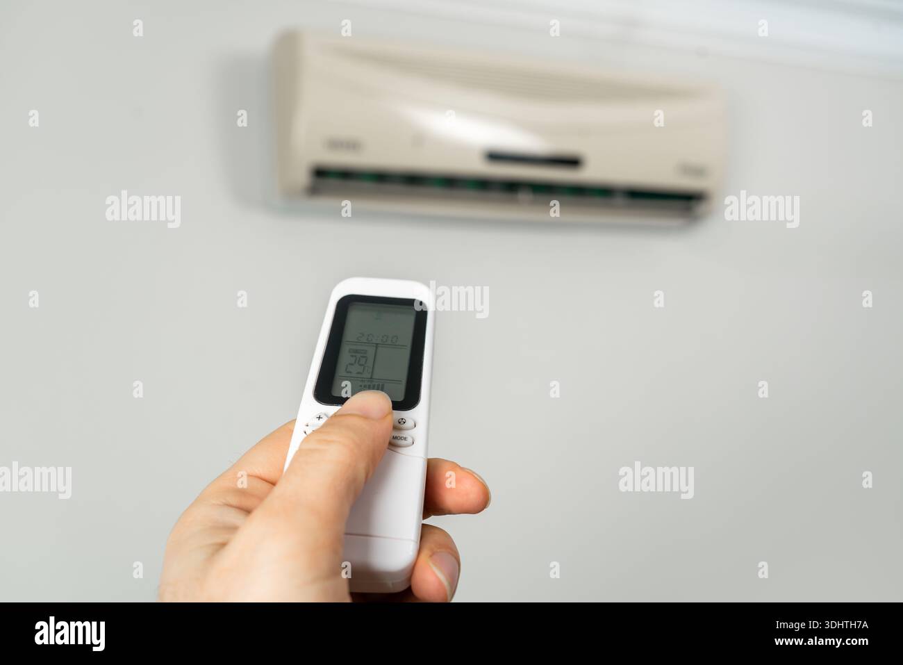 Hand Using Remote Control for Air Conditioner. High quality photo Stock Photo