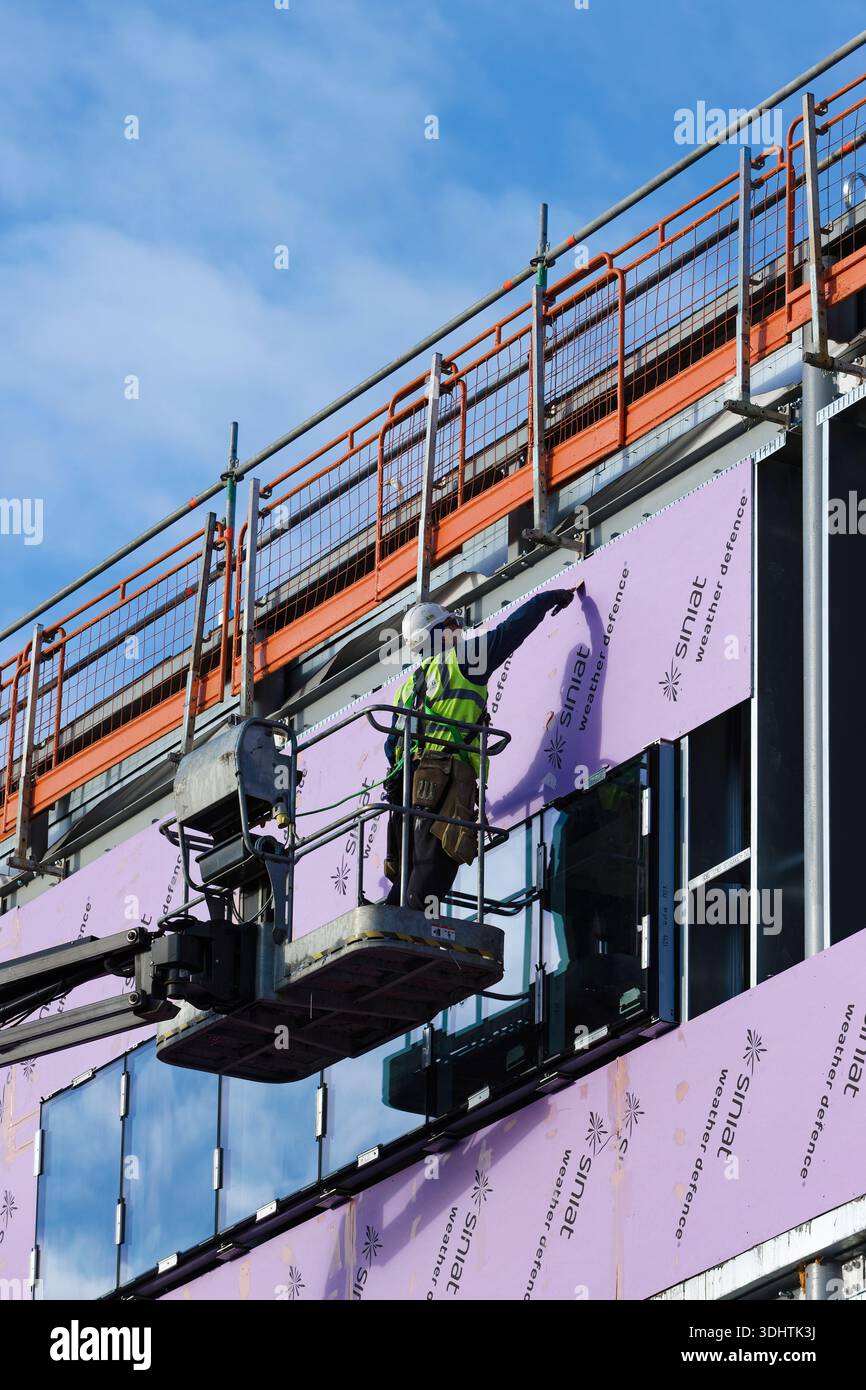 Construction worker on boom lift seals weather defence external ...
