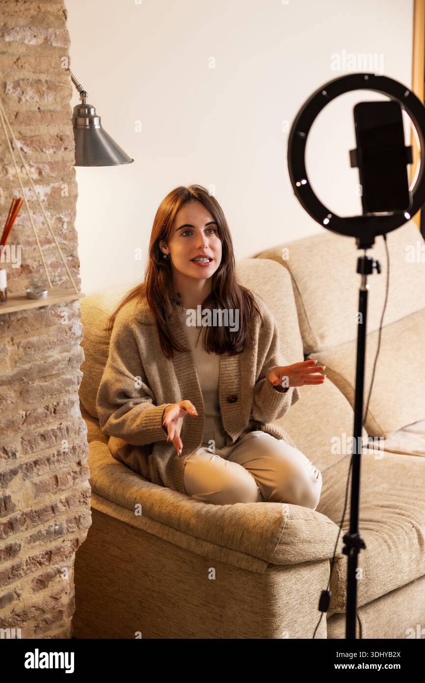 Female vlogger recording video content using smartphone and ring light Stock Photo
