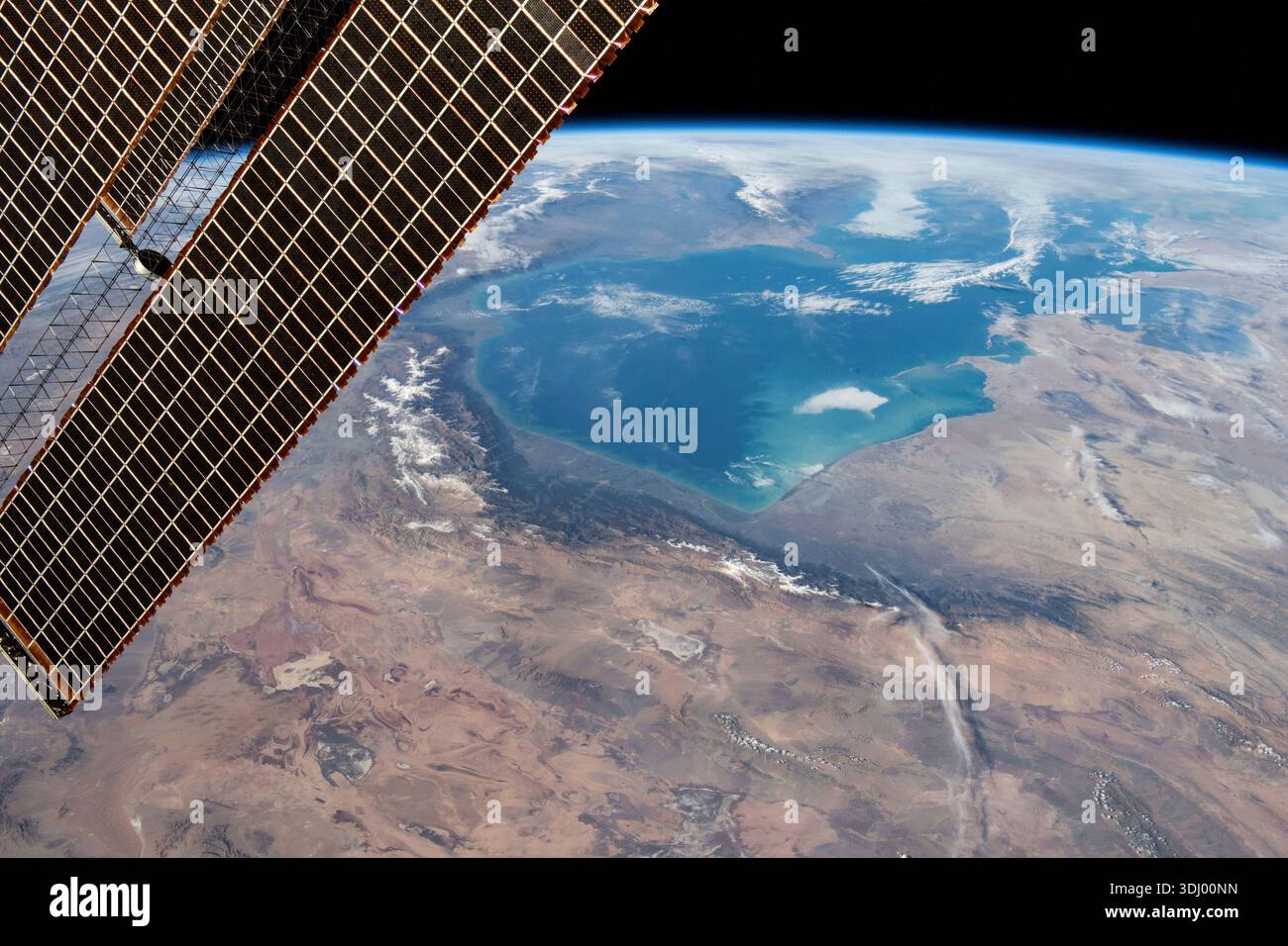 The Persian Gulf from orbit. In the foreground, one of the International Space Station's solar arrays is visible, detailing the intricate solar cells that make up the hardware. A photograph taken from the International Space Station on 30 November 2023.  An optimised version of an original NASA image: Credit: NASA/JMoghbeli Stock Photo