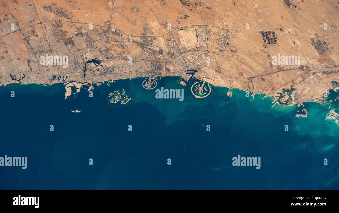 Coastline of the United Arab Emirates, Dubai, and the arjpgicial Palm Islands archipelagos seen from orbit. Palm Jumeirah (centre-left) and Palm Jebel Ali (centre-right). The islands were constructed using millions of cubic meters of sand to create land in the shape of palm trees extending into the Persian Gulf. Another set of arjpgicial islands, known as 'The World Islands,' shaped like a map of the globe, can be seen to the left of the Palm Jumeirah. A photograph taken from the International Space Station on 29 January 2025 An optimised version of an original NASA image: Credit: NASA Stock Photo