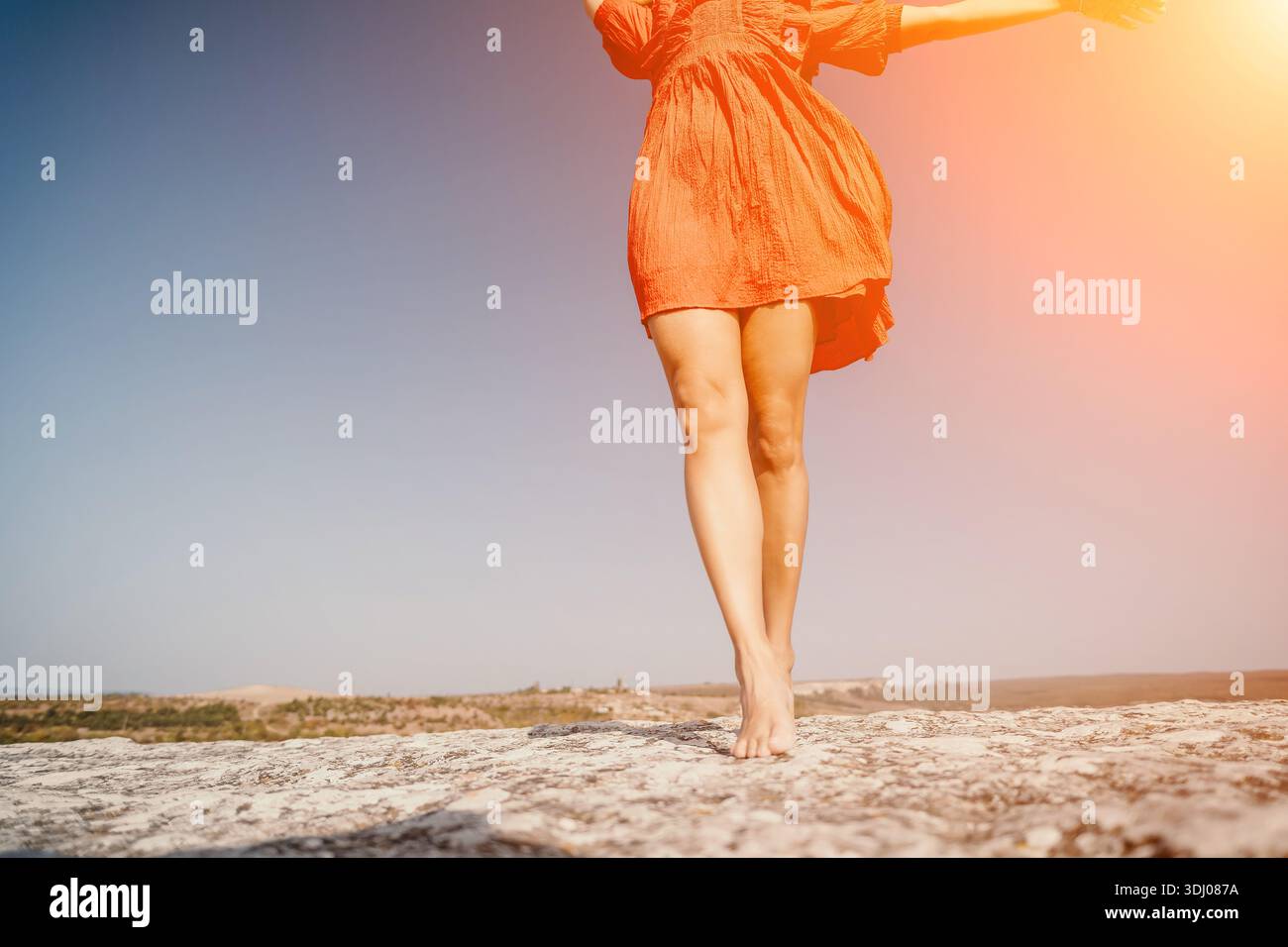 Barefoot Woman in Red Dress Walking on a Rocky Surface Stock Photo - Alamy