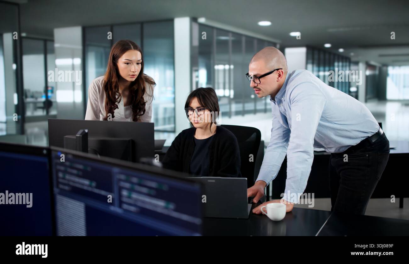 Two Coders Lead Diverse Team Developing Software Solutions In Office. Stock Photo