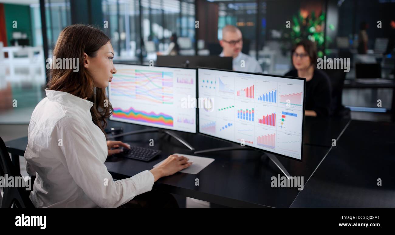 Skilled Business Analyst Team Analyzing Data Using Multiple Computers Stock Photo