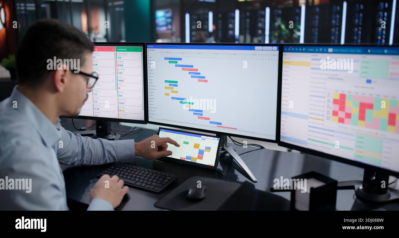 Busy Businessman Managing Multiple Projects On Digital Scheduling Software At Work. Stock Photo