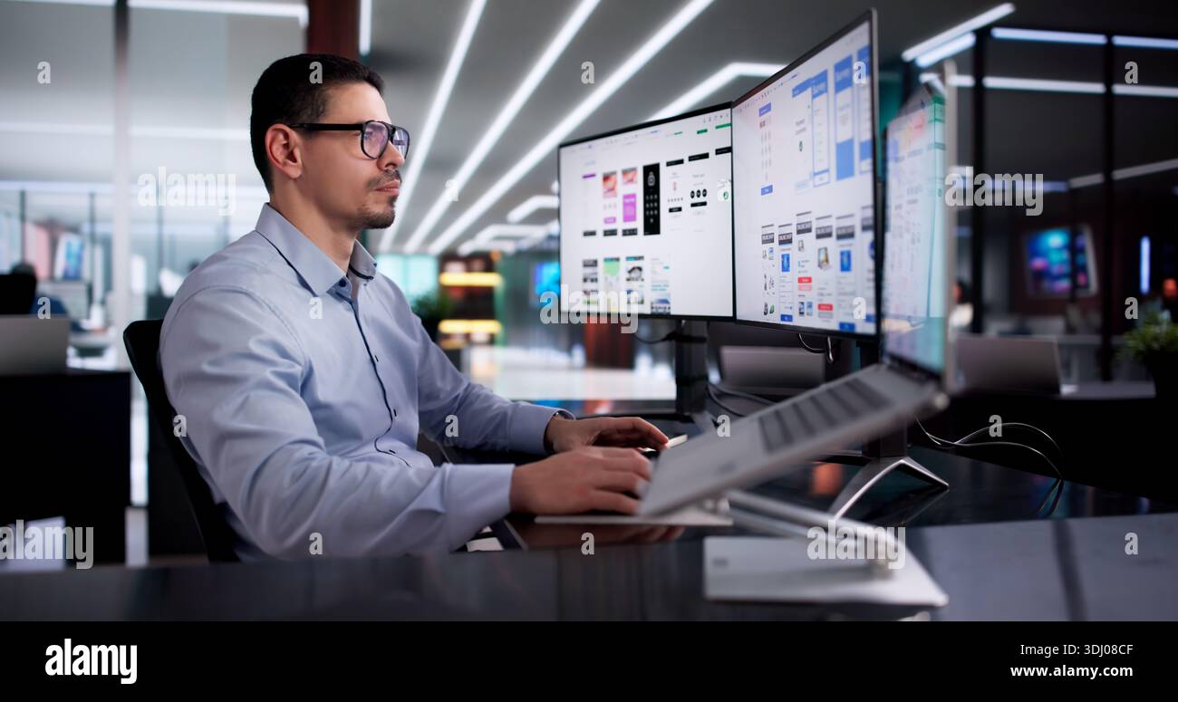 Young Latino Designer Creating User Experience Interface On Computer App Stock Photo
