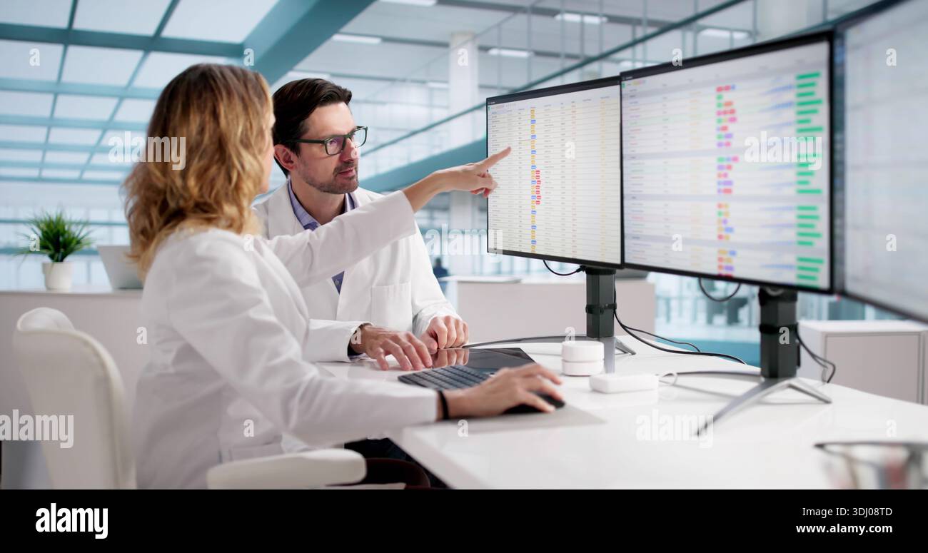 Medical Professionals Reviewing Bill Codes On Multiple Monitors ...