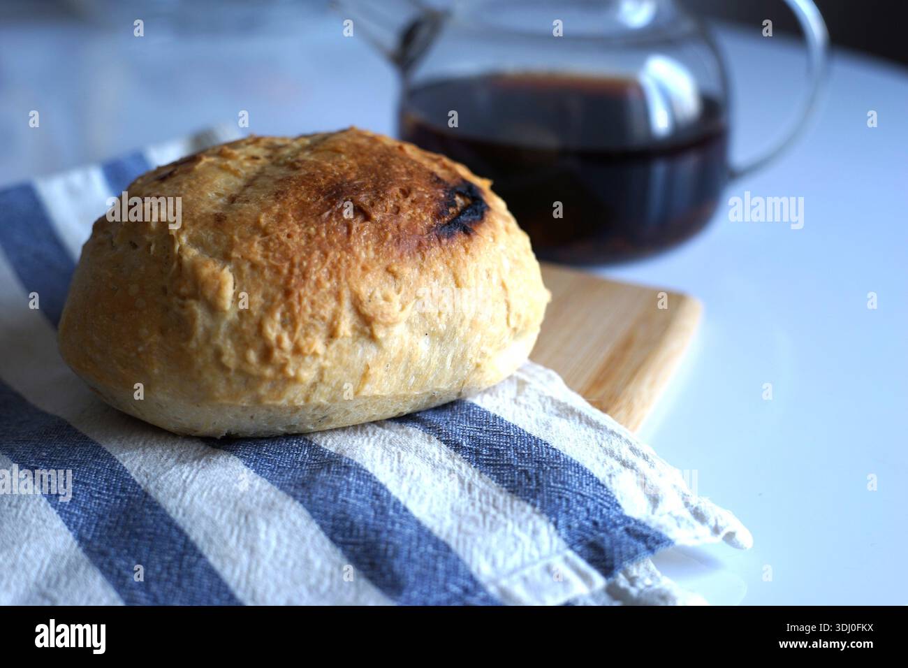 Fresh bread on a linen towel on the kitchen table Stock Photo
